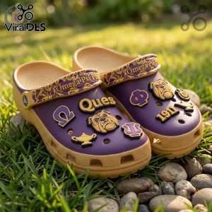 Omega Psi Phi Mascot Slip On Clogs With Charms in purple and gold with bulldog emblems on a grass background.