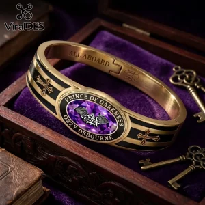 Ozzy Osbourne Prince of Darkness gold tone toggle bracelet with black enamel, a central purple gem, and cross detailing.