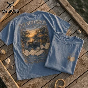 The Notebook Soft Love Era blue t-shirt with a vintage lake scene, rowing boat, and handwritten letters print on back.