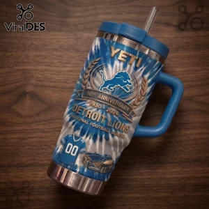 Detroit Lions 96th Anniversary Tie Dye YETI Tumbler with blue spiral pattern, team logo, and jersey icon on wooden table.