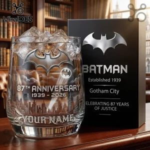 Batman 87th Anniversary Custom Whiskey Glass with a Gotham City skyline etching and a silver logo on a black display box.