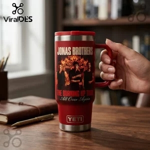 Jonas Brothers The Burning Up Tour Red StanleyTumbler featuring band members and flaming graphic text on a red background.