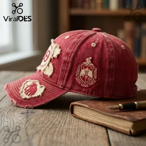 Delta Sigma Theta Sorority Distressed Crimson Baseball Cap with embroidered crest and elephant patch on a wooden surface.