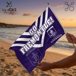 Fremantle Dockers Purple Double Sided House Flag with anchor logo and chevron stripes held against a sunset beach backdrop.