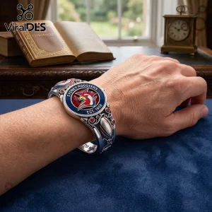 Sydney Roosters Easts To Win bracelet in silver with team logo and red accents worn on a wrist against a blue background.