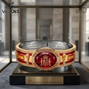 Spain 2026 World Cup Champion Bracelet featuring a red gemstone, gold detailing, and trophy engravings in a display case.