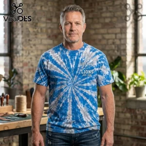 Detroit Lions NFL One Pride Special Edition Shirt in blue and white tie-dye on a man against a brick studio background.