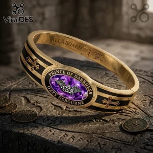 Ozzy Osbourne Prince of Darkness gold tone toggle bracelet featuring a purple oval stone, bat logo, and cross accents.