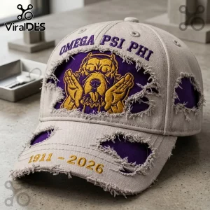 Omega Psi Phi 1911-2026 Distressed Mascot Baseball Cap with purple and gold embroidery on a beige ripped fabric base.