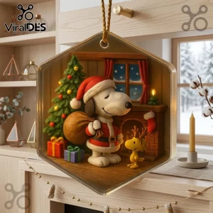 Snoopy and Woodstock Christmas Ornament 2026 featuring Snoopy in a Santa suit and Woodstock by a fireplace and tree.
