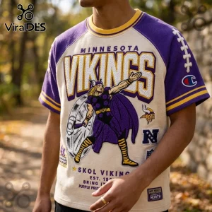 Minnesota Vikings Embroidered Mascot Champion Shirt featuring purple sleeves, cream body, and Norse warrior graphic.