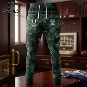 New Zealand Warriors 2026 Junior Te Taiao hoodie joggers featuring a green fern print, team logos, and white drawstrings.