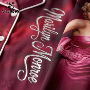 Marilyn Monroe 100th Anniversary Burgundy Satin Pajama Set featuring white piping, button detail, and cursive embroidery.