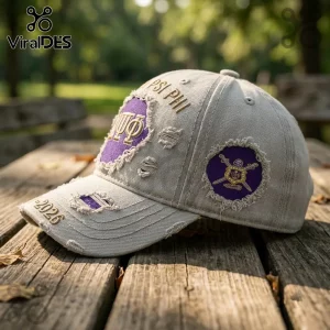 Omega Psi Phi 1911-2026 distressed baseball cap in beige with purple patches, Greek embroidery, and a frayed aesthetic.