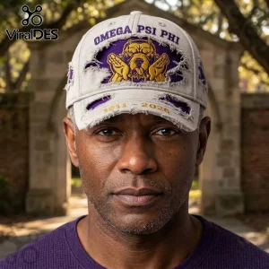 Omega Psi Phi 1911-2026 Distressed Mascot Baseball Cap in grey with purple accents, gold bulldog emblem, and frayed edges.