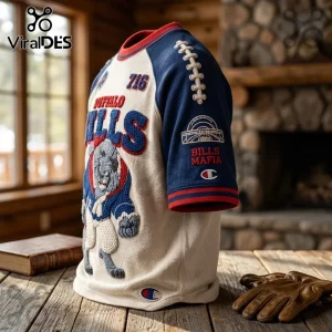 Buffalo Bills NFL Embroidered Mascot Shirt featuring a cream body, blue sleeves, Bills logo, and 716 text on a table.