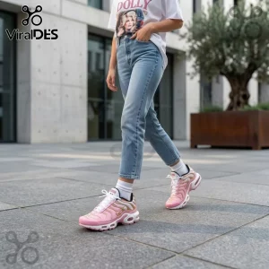 Dolly Parton Limited Edition Pink Air Max Plus shoes with gold accents worn by a person in blue jeans.