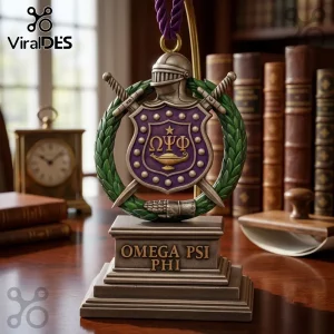 Omega Psi Phi Shield 2026 Christmas ornament featuring a crest with swords, a helmet, and Greek letters on a pedestal base.
