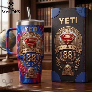 Superman 88th Anniversary Tie Dye 40oz Tumbler with logo, Daily Planet graphics, and metal straw on a wooden desk surface.