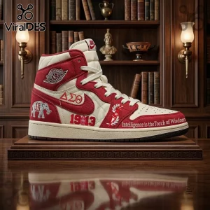 Delta Sigma Theta 1913 Air Jordan 1 High Top Sneakers in crimson and cream with elephant and torch symbols on a library shelf.