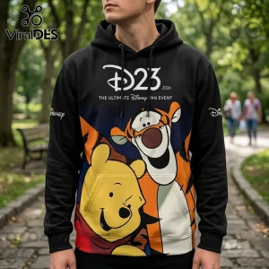 Disney x Winnie the Pooh D23 2026 black hoodie featuring Tigger and Pooh Bear graphic prints against a blurred park background.