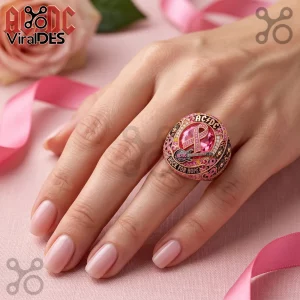 AC/DC Rock For Hope Breast Cancer Awareness ring featuring a pink ribbon, a guitar motif, and pavé crystals on a hand.