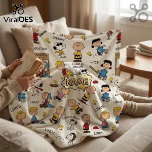 Peanuts Snoopy personalized fleece blanket featuring a cream background with various comic character illustrations and names.