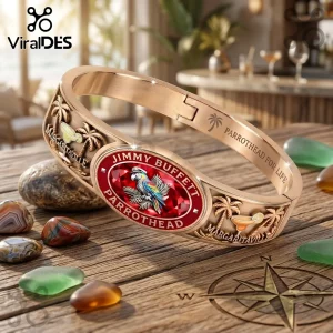 Jimmy Buffett Margaritaville gold tone engraved bracelet with red center emblem, palm trees, and parrothead detailing.
