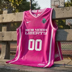 New York Liberty Rock The Pink 2026 basketball jersey in vibrant pink with white lettering on a concrete park bench.