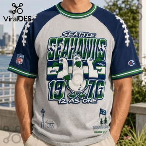 Seattle Seahawks 1976 Embossed Mascot Shirt with raglan sleeves, featuring seagull graphics and Emerald City illustrations.