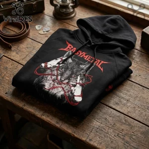 Babymetal 2026 World Tour Wolf Mascot Black Hoodie featuring red thread graphic and metal font on a wooden table surface.