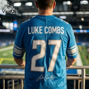 Detroit Lions Luke Combs 2027 Tour blue football jersey with white lettering and number 27 on back, worn in stadium setting.