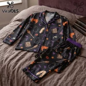 Hocus Pocus Sanderson Sisters Black Pajama Set featuring prints of spellbooks, brooms, cats, and witch hair on a bed.