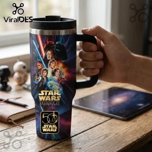 Star Wars Episode IV 50th Anniversary 40oz Tumbler with character graphics, black lid, and handle on a wooden desk.