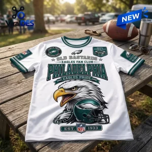 Philadelphia Eagles Old Bastards Mascot T-Shirt with eagle graphic, football helmet, and green trim on a wooden table.