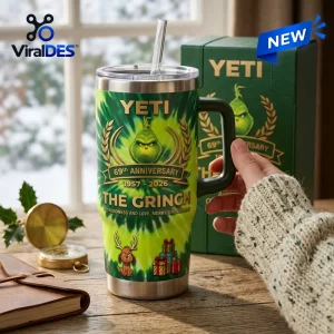Hand holding green Yeti The Grinch 69th Anniversary Handle Tumbler on wooden table.