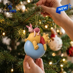 Close-up view of a holiday ornament featuring two cartoon characters on a blue balloon hanging on a Christmas tree.