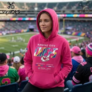 Kansas City Chiefs Crucial Catch Pink Hoodie worn by a woman at a stadium with team logo and charity branding text.