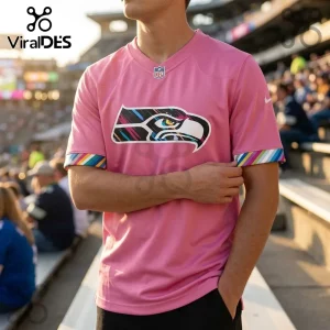 Seattle Seahawks 2026 Crucial Catch Pink Football Jersey featuring a multicolored logo and striped sleeve cuffs on a male.