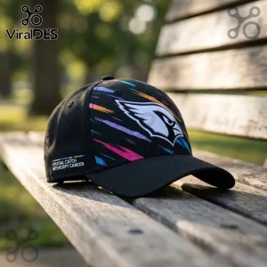 Arizona Cardinals NFL Crucial Catch Black Cap with multi-colored brushstroke design and team logo on a wooden bench.