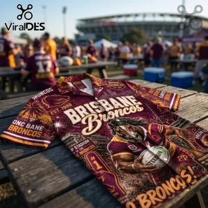 Brisbane Broncos Maroon Hawaiian Shirt featuring NRL graphics, gold horse logo, and stadium imagery on a wooden table.