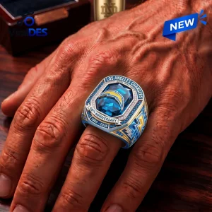 Closeup of a hand wearing the Los Angeles Chargers 66th Anniversary Ring with blue stone and gold lightning bolt details.
