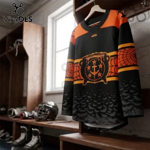 Norfolk Admirals 2026 Halloween Orange Black Hockey Jersey with a cauldron anchor graphic hanging in a locker room.