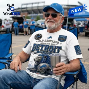 Detroit Lions Old Bastards Mascot T-Shirt featuring a lion graphic, blue text, and stadium imagery on a white cotton base.