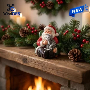 Front view of Cozy Santa figurine holding a grey tabby cat on a wooden mantelpiece.