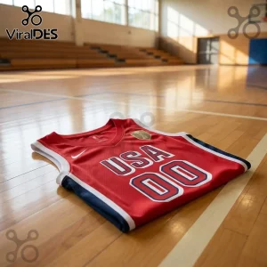 USA Women's Basketball 2026 FIBA World Cup red jersey with white and blue trim folded on a polished wooden court floor.