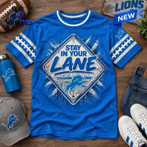 Front view of a blue t-shirt featuring a street sign graphic with the text Stay In Your Lane and a lion logo.