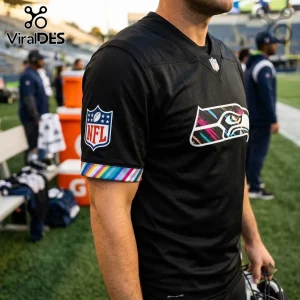Seattle Seahawks 2026 Crucial Catch Black Football Jersey with a multicolor logo and sleeve trim on a player at a stadium.