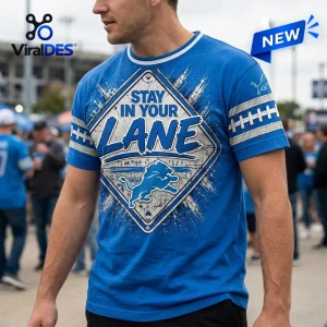 Front view of a blue t-shirt featuring a street sign graphic with the text STAY IN YOUR LANE and a lion logo.