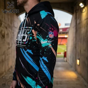 Kansas City Chiefs 2026 Crucial Catch Black Pullover Hoodie with neon paint splatter design, NFL logo, and drawstring hood.